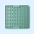 A square mint green silicone dish drying rack with a textured grid pattern, shown on a light blue background.